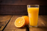 Glass of orange juice and sliced fresh orange
