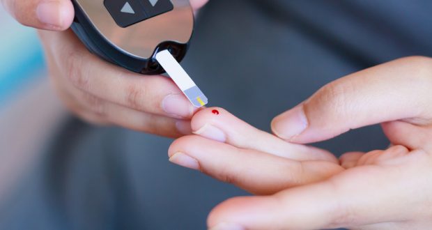 Testing blood sugar on finger with glucometer