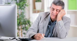 exhausted man sitting in front of computer