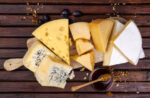 several cheeses on wooden cheese board
