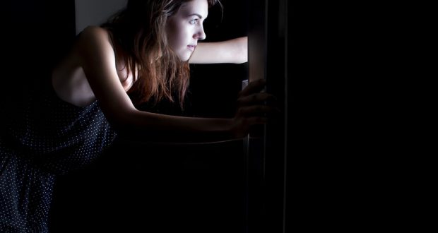 woman looking in fridge late at night craving