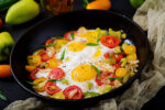 Fried eggs and veggies in cast iron skillet