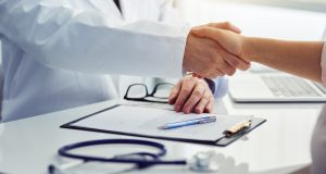 Physician shaking hands with patient