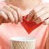 Woman adding artificial sweetener to coffee cup