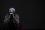 Older man sits alone, appearing depressed