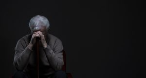 Older man sits alone, appearing depressed